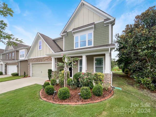 craftsman inspired home with a garage and a front lawn