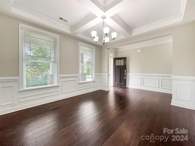 empty room with hardwood / wood-style flooring, a chandelier, crown molding, beam ceiling, and coffered ceiling