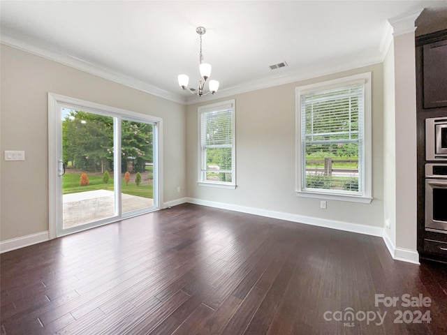 interior space with dark wood-type flooring, ornamental molding, a chandelier, and a healthy amount of sunlight