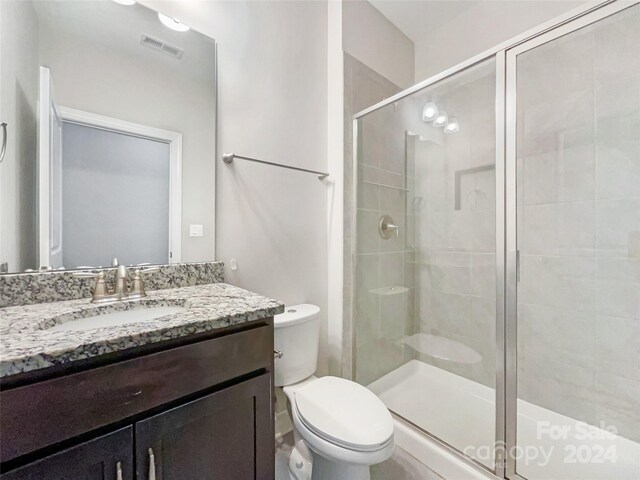 bathroom featuring vanity, toilet, and walk in shower