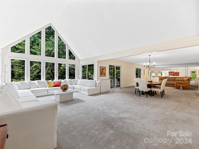 carpeted living room with a notable chandelier and high vaulted ceiling