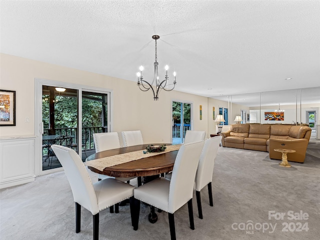 dining space with light carpet, a textured ceiling, and a chandelier