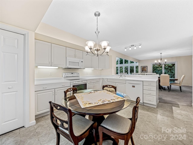 dining room featuring sink, an inviting chandelier, a textured ceiling, light tile patterned floors, and track lighting