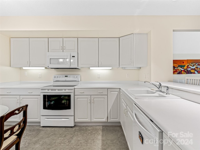 kitchen with light tile patterned flooring, sink, white appliances, and white cabinetry