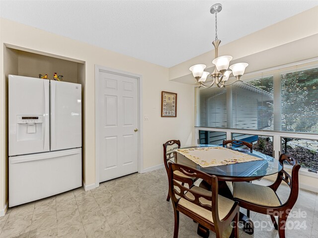 tiled dining room with an inviting chandelier