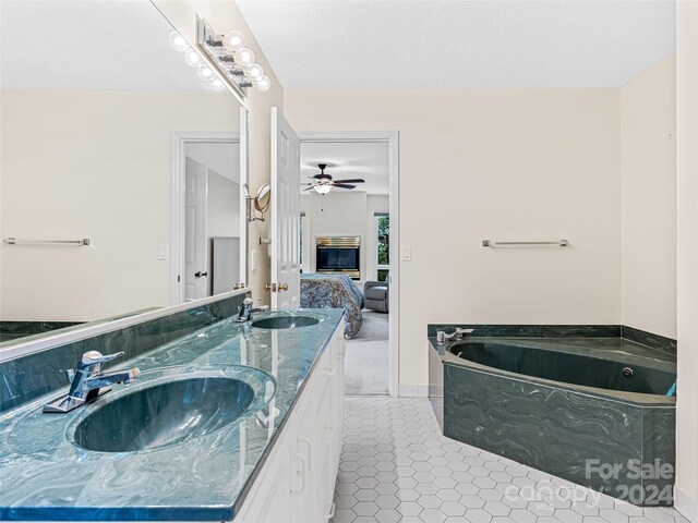 bathroom featuring a textured ceiling, tile patterned floors, ceiling fan, a bath, and double sink vanity