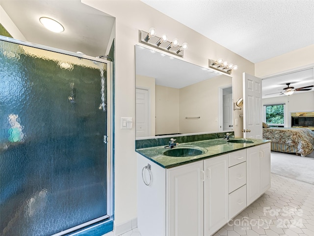 bathroom with ceiling fan, a textured ceiling, tile patterned floors, and dual bowl vanity