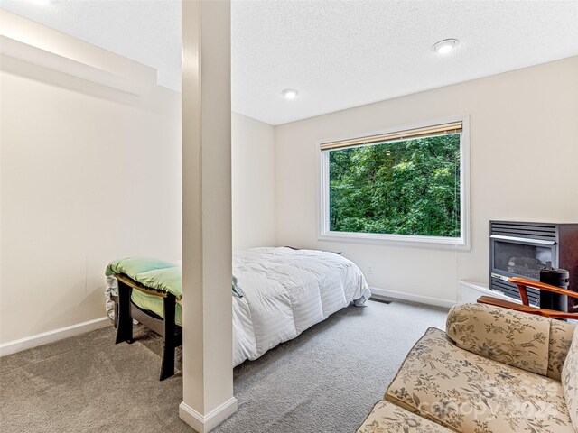 bedroom with a textured ceiling and light colored carpet