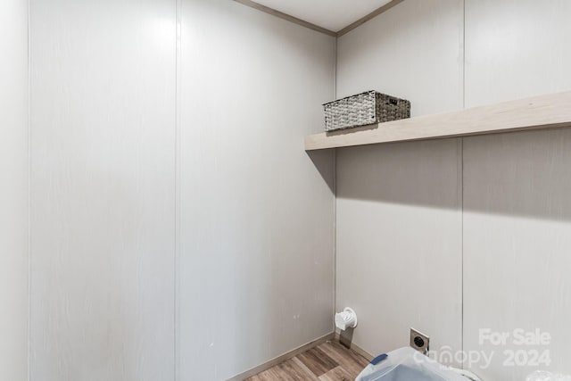 laundry area with ornamental molding, light hardwood / wood-style flooring, and hookup for an electric dryer