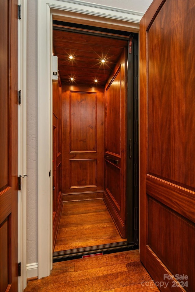 details featuring hardwood / wood-style flooring and elevator