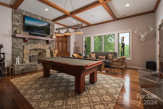 playroom with coffered ceiling, hardwood / wood-style floors, a stone fireplace, and beamed ceiling