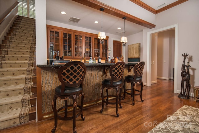 bar with dark hardwood / wood-style floors, decorative light fixtures, and crown molding