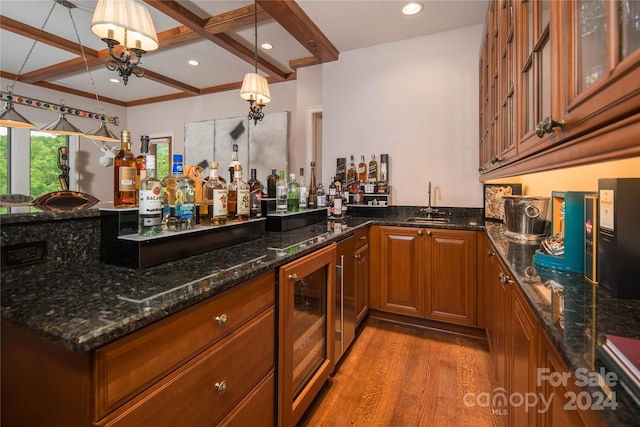 bar with coffered ceiling, wood-type flooring, pendant lighting, dark stone counters, and beverage cooler