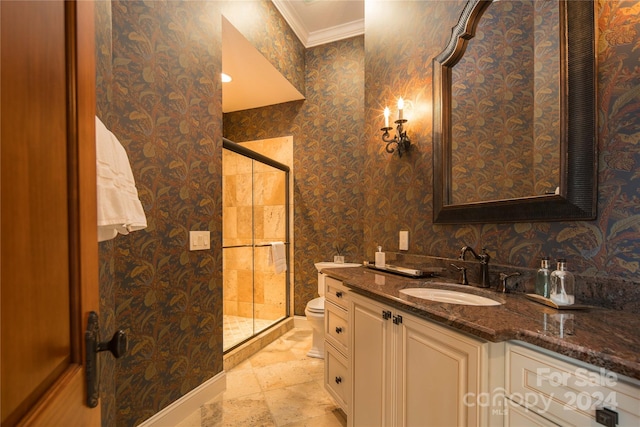 bathroom featuring vanity, toilet, crown molding, and a shower with shower door