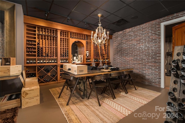 wine room with brick wall and a drop ceiling