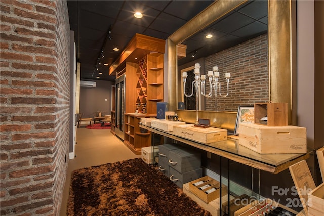 bar featuring brick wall, a wall mounted AC, and built in desk