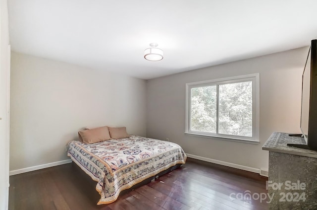 bedroom with dark wood-type flooring