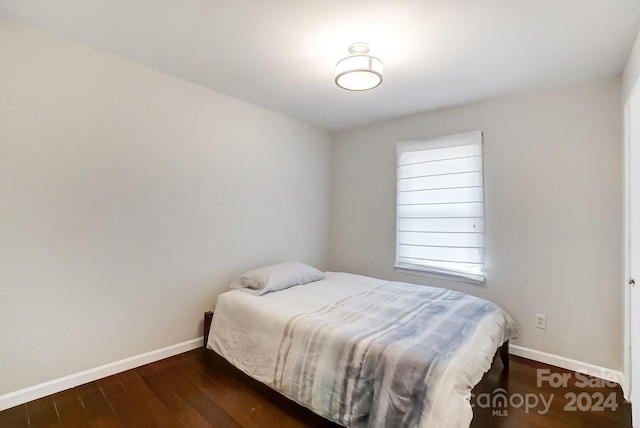 bedroom with dark hardwood / wood-style floors