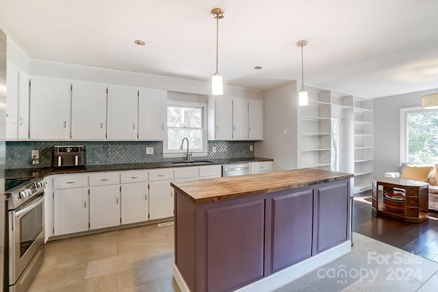 kitchen with stainless steel appliances, sink, pendant lighting, white cabinets, and butcher block countertops