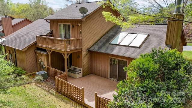 back of property featuring cooling unit and a deck