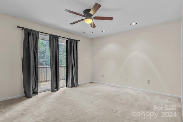 carpeted spare room with baseboards and a ceiling fan