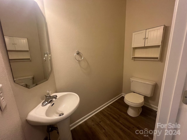 bathroom with hardwood / wood-style flooring, sink, and toilet