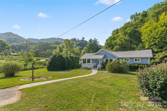 ranch-style house featuring a mountain view and a front lawn