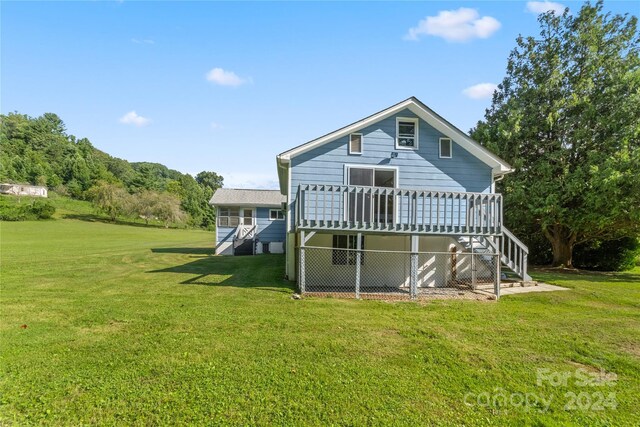 rear view of property with a yard and a deck