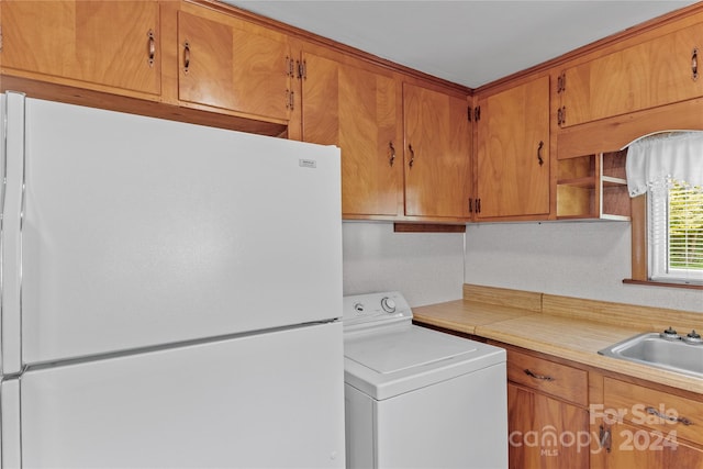 kitchen with white refrigerator, sink, and washer / clothes dryer