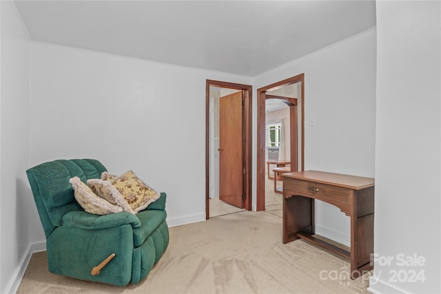 living area with ornamental molding and light colored carpet