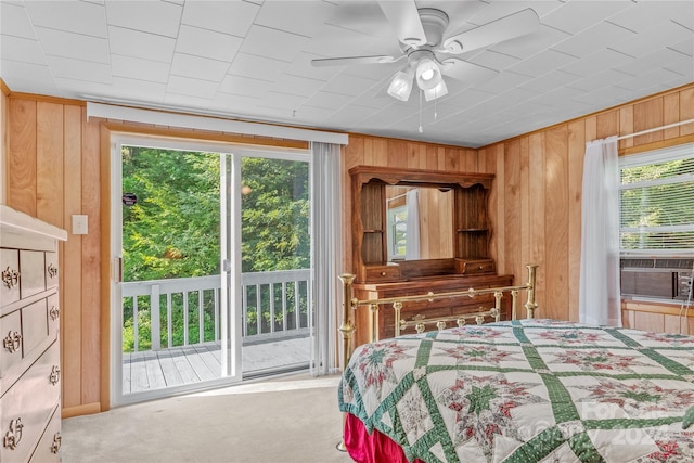 bedroom with cooling unit, carpet flooring, access to exterior, and wood walls