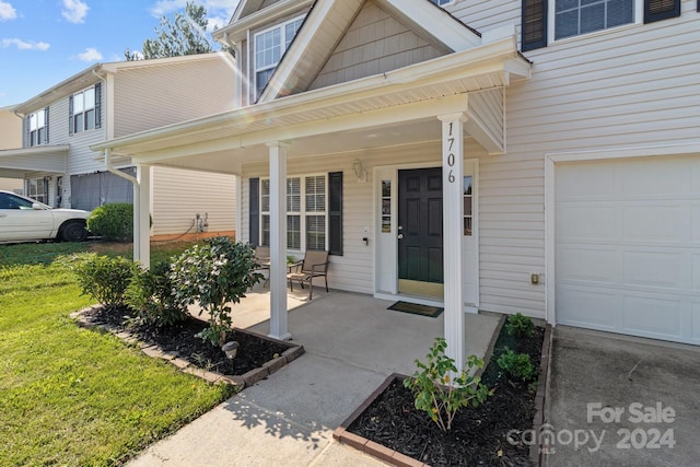 doorway to property featuring covered porch and a garage