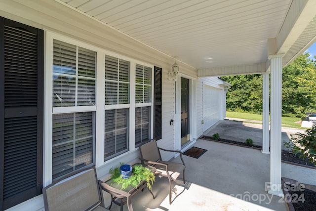 view of patio featuring covered porch and a garage