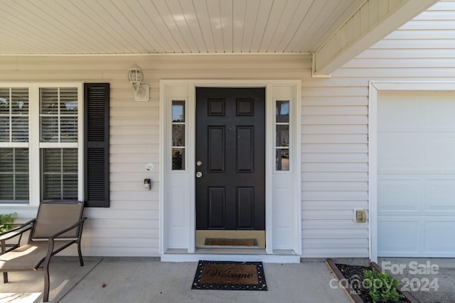 property entrance with a garage and covered porch