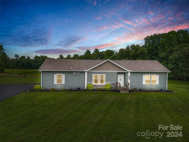 ranch-style home featuring a lawn