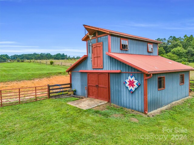 view of outdoor structure with a rural view and a yard