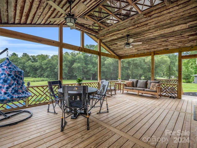 unfurnished sunroom with vaulted ceiling, a healthy amount of sunlight, and ceiling fan