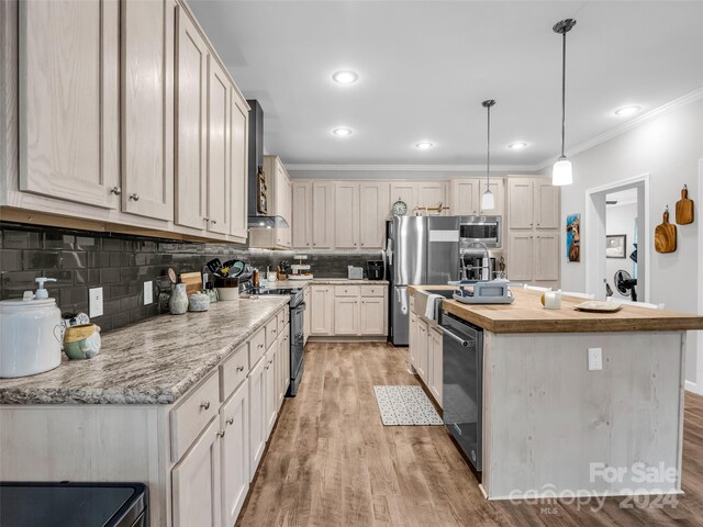 kitchen featuring light hardwood / wood-style flooring, pendant lighting, backsplash, stainless steel appliances, and a kitchen island