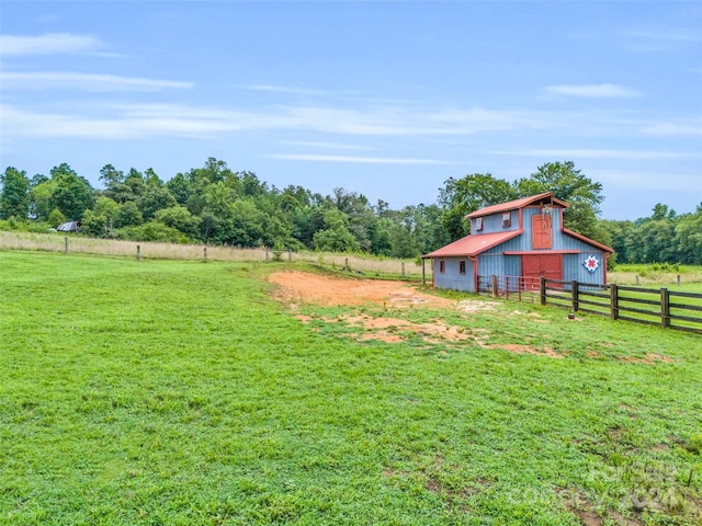 view of yard with an outbuilding and a rural view