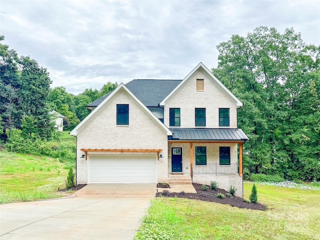 view of front facade featuring a garage, a front yard, and covered porch