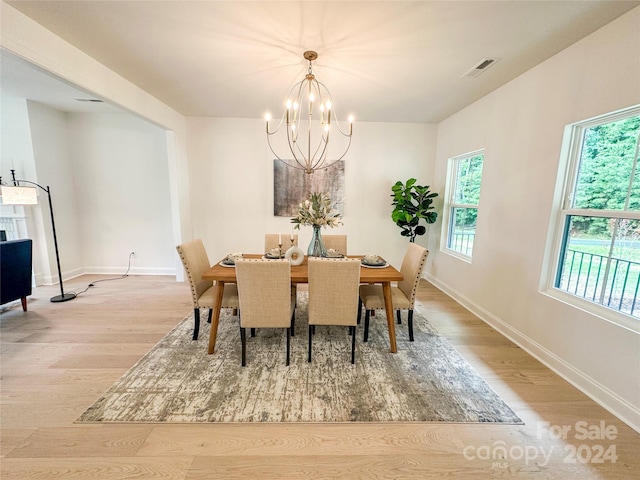 dining room with light hardwood / wood-style flooring and a chandelier