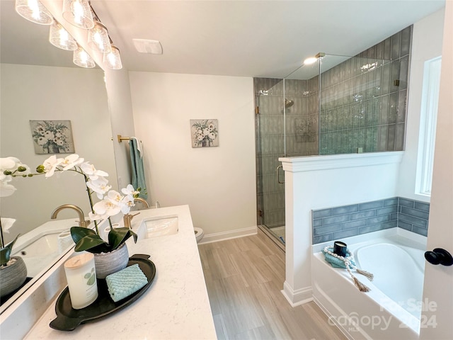 full bathroom featuring plus walk in shower, hardwood / wood-style floors, vanity, and toilet