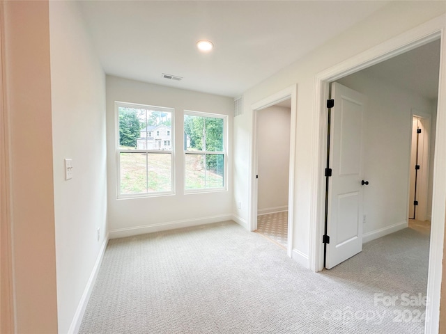 spare room featuring light colored carpet