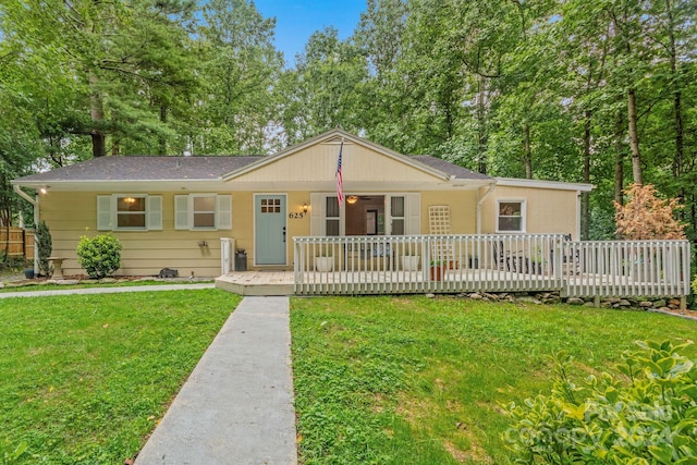 ranch-style house with a wooden deck and a front lawn