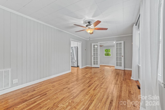 spare room featuring light hardwood / wood-style flooring, ceiling fan, french doors, and crown molding