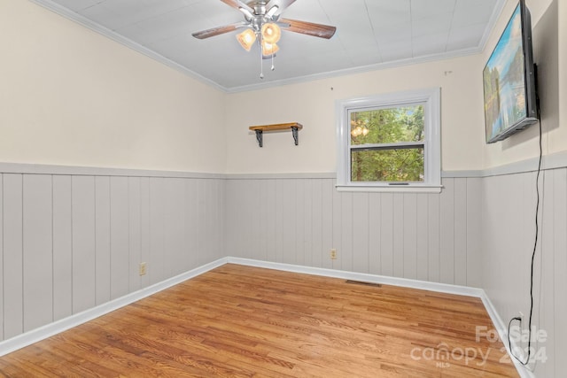 empty room with crown molding, light hardwood / wood-style flooring, and ceiling fan