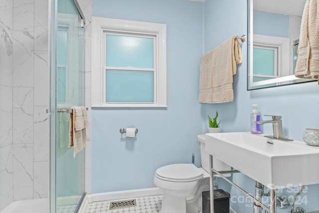 bathroom featuring a shower with shower door, toilet, tile patterned flooring, and sink