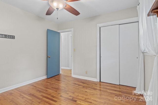 unfurnished bedroom with light hardwood / wood-style floors, a closet, and ceiling fan