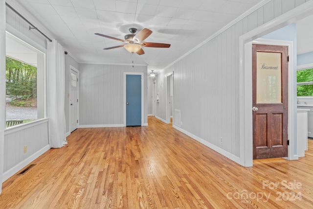 empty room with light hardwood / wood-style floors, a wealth of natural light, and ceiling fan