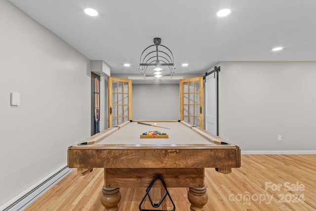 recreation room with a barn door, a baseboard heating unit, light hardwood / wood-style floors, and pool table